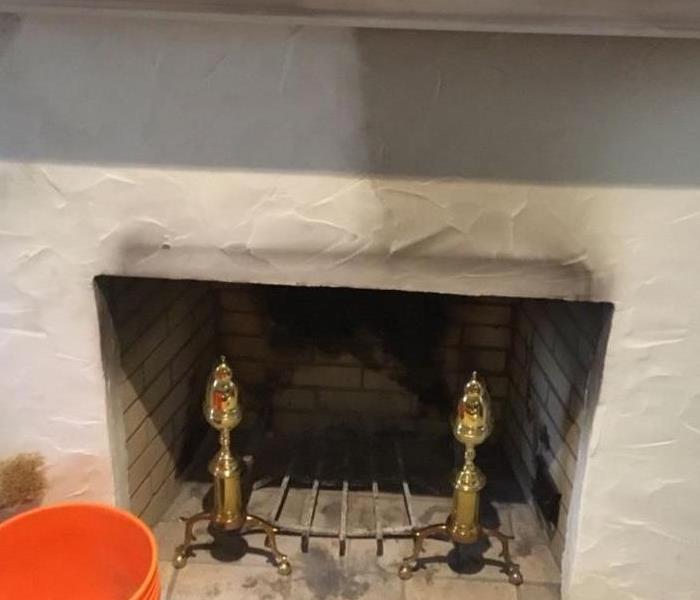 White fireplace half clean with Soot