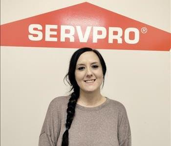 Lindsey, office secretary, pictured in front of SERVPRO logo 