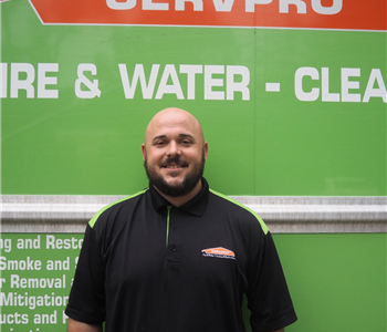 SERVPRO employee pictured in front of green background