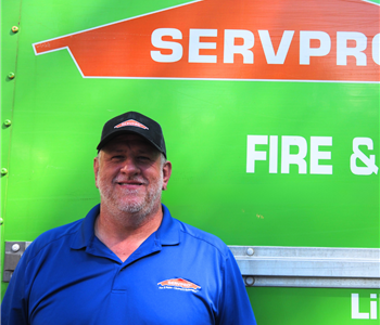 SERVPRO employee pictured in front of green background