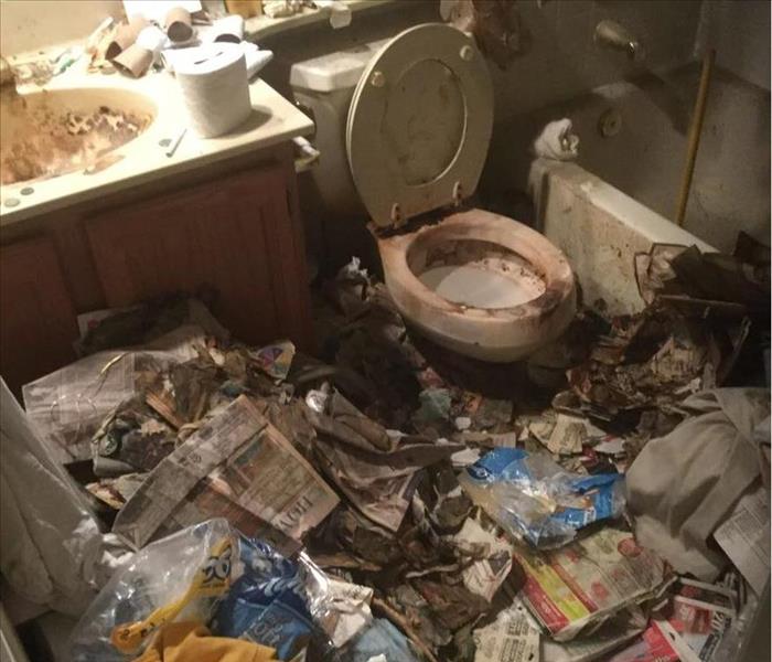 dirty bathroom with old newspapers and plastic bags