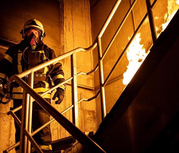 firefighter in stairwell extinguishing fire.
