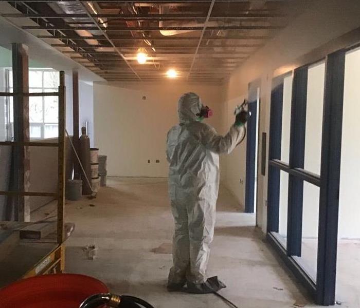 Man in PPE fogging building